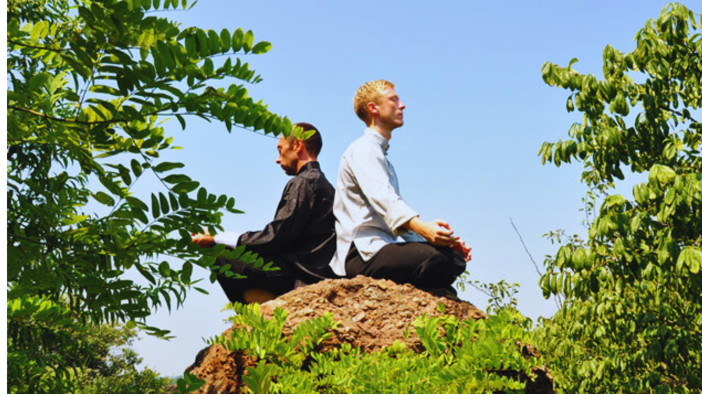 students meditating on a hill
