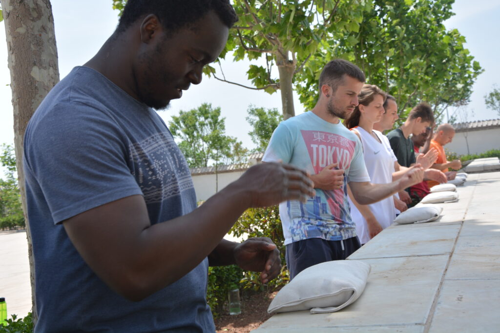 kung fu students conditioning while bunching bags of iron balls