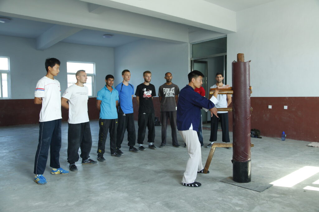 master demonstrating wing chun drills to students