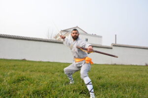 stduent testimonials Avi posing with a straight sword in the field