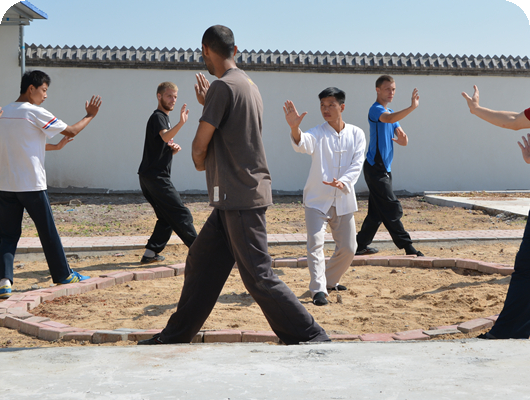 students and master practicing bagua in sandpit circle