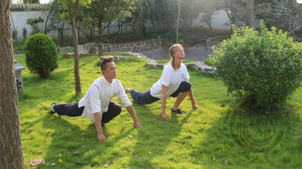 meester bao en student stretchen met qigong, waarbij gebruik wordt gemaakt van neigong