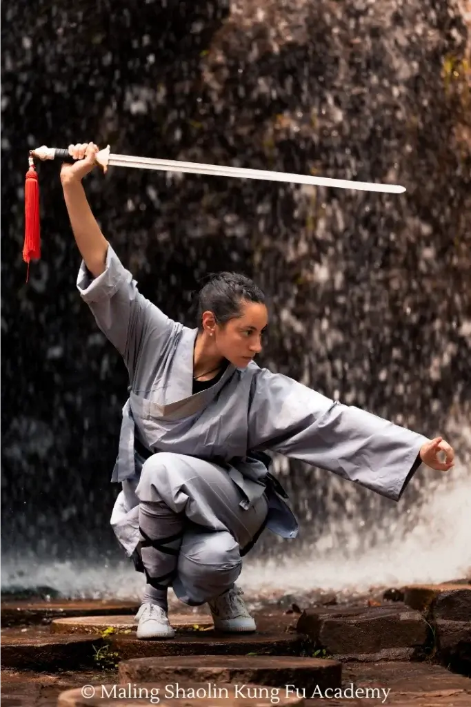 Student Ream practicing Shaolin straight sword in front of waterfall.